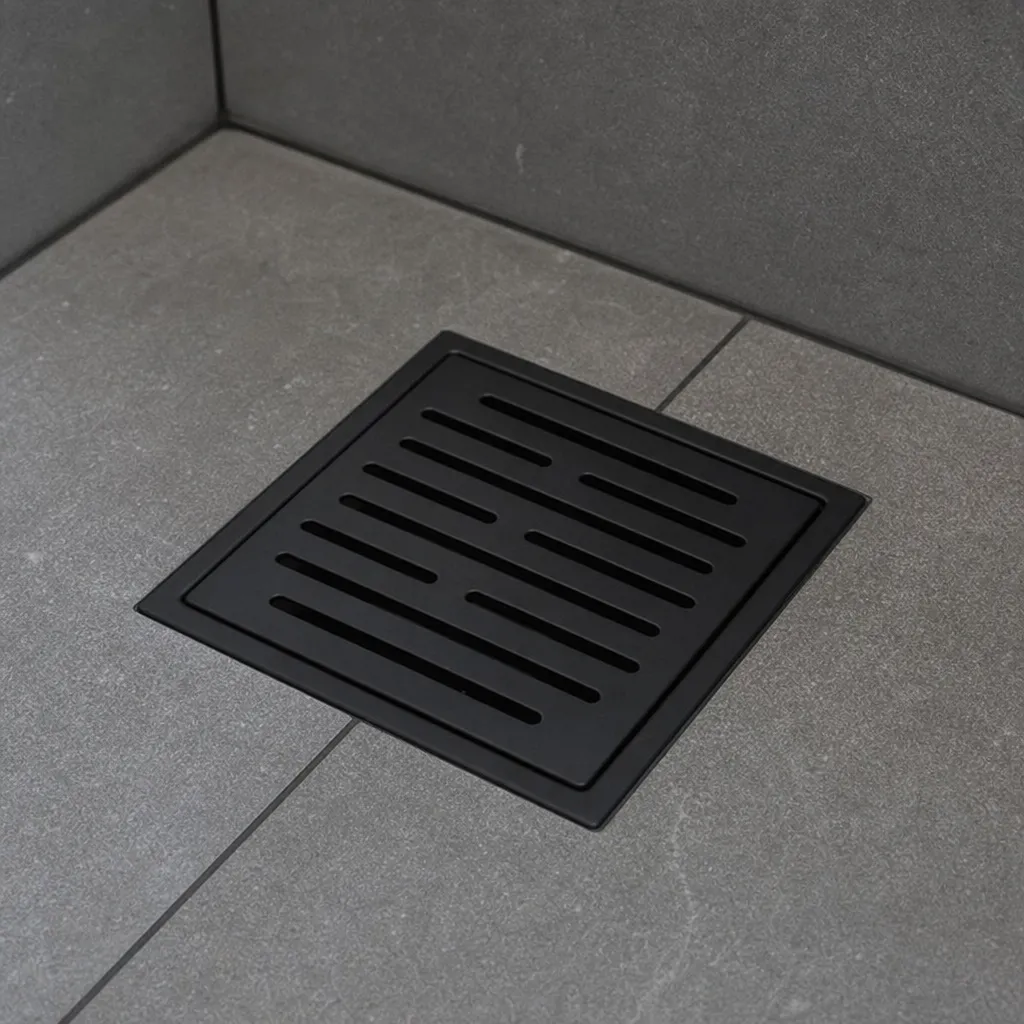 Nahaufnahme einer eleganten, mattschwarzen Zierabdeckung für den Abfluss in einer gefliesten Dusche